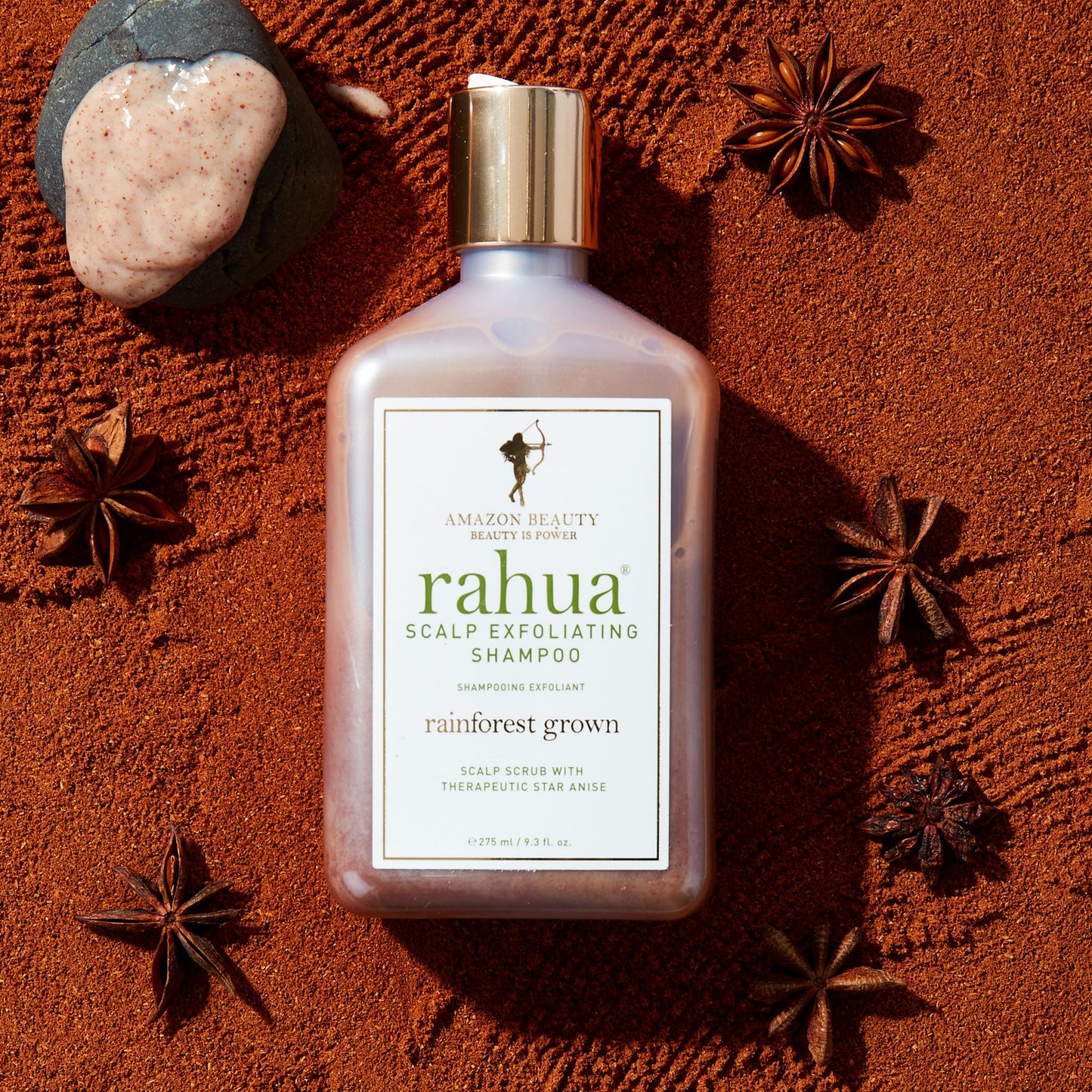 Rahua scalp exfoliating shampoo with natural ingredient star anise and sacha inchi placed on a brown sand|variant:full-size