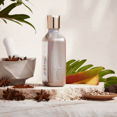 Rotating scalp exfoliating shampoo on a marble block with mango slice and star anise in herbal product equipment|variant:full-size