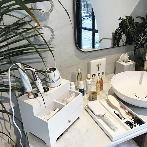 Range of rahua products with other hair essential tools placed near a basin and mirror at NYC flagship store of detox market