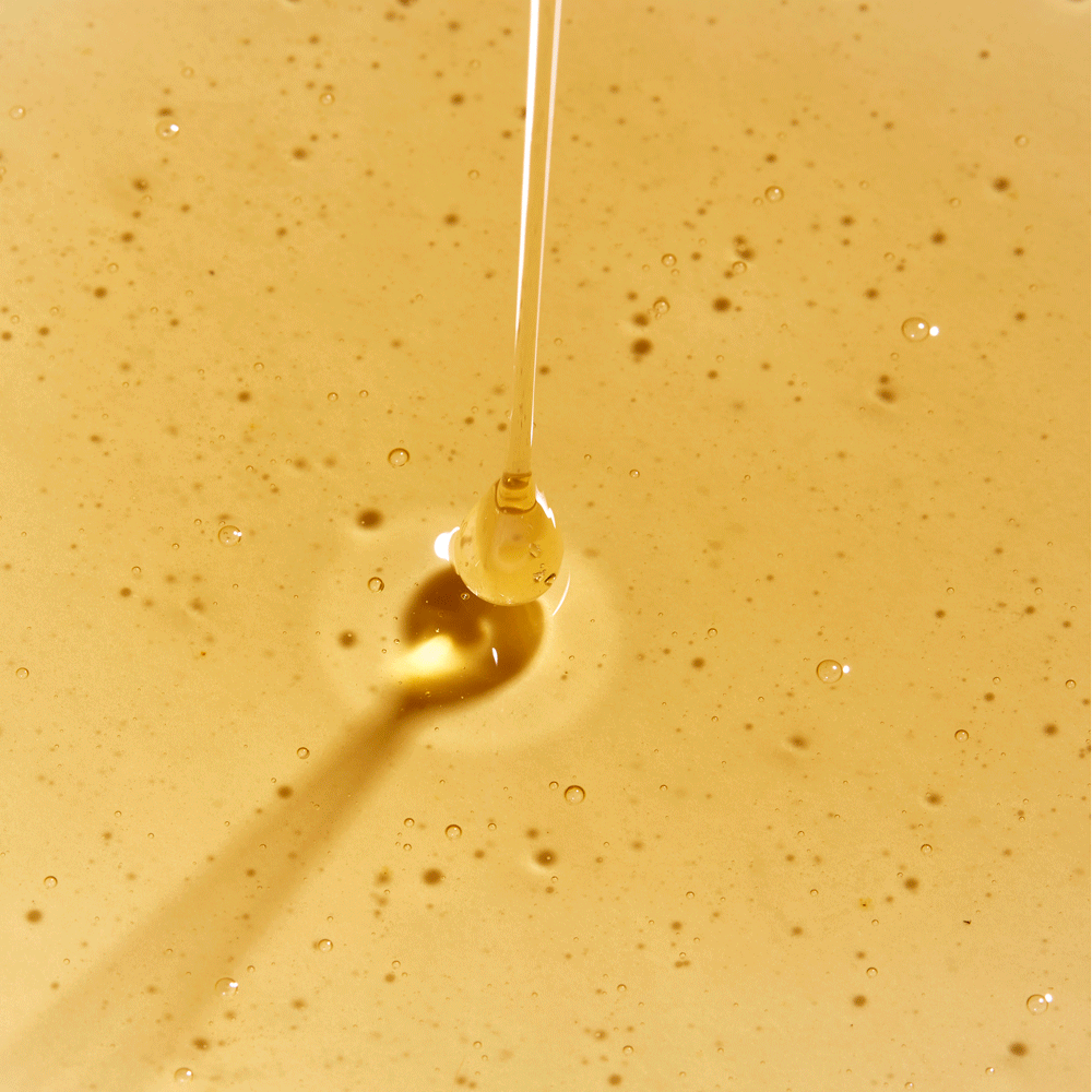 gif of rahua classic shampoo being poured out onto a puddle of classic shampoo on a flat surface to show texture of product shampoo is golden and somewhat thick|variant:16-oz