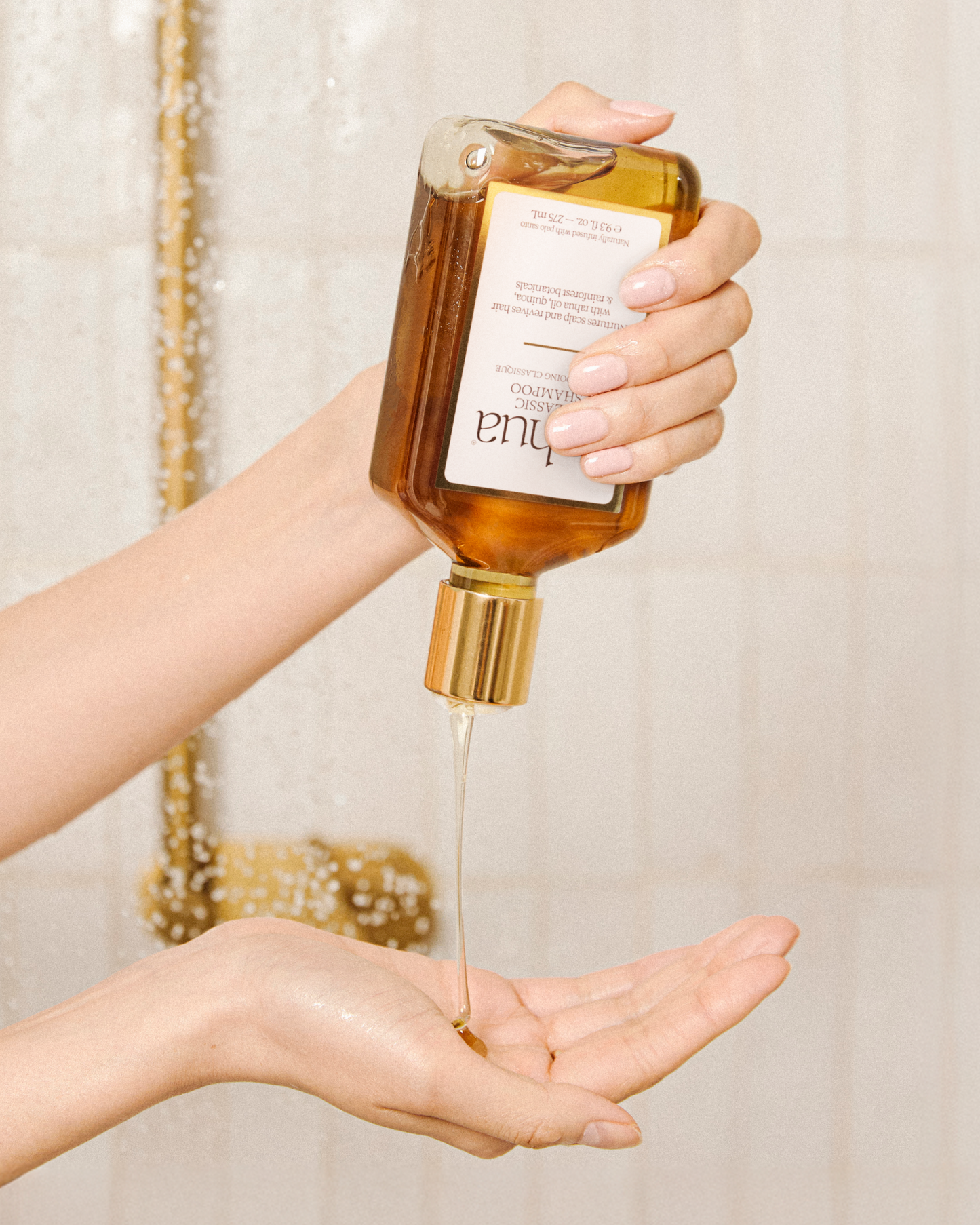 Hand holding a bottle of Tula skincare product with dropper over another hand.|variant:16-oz