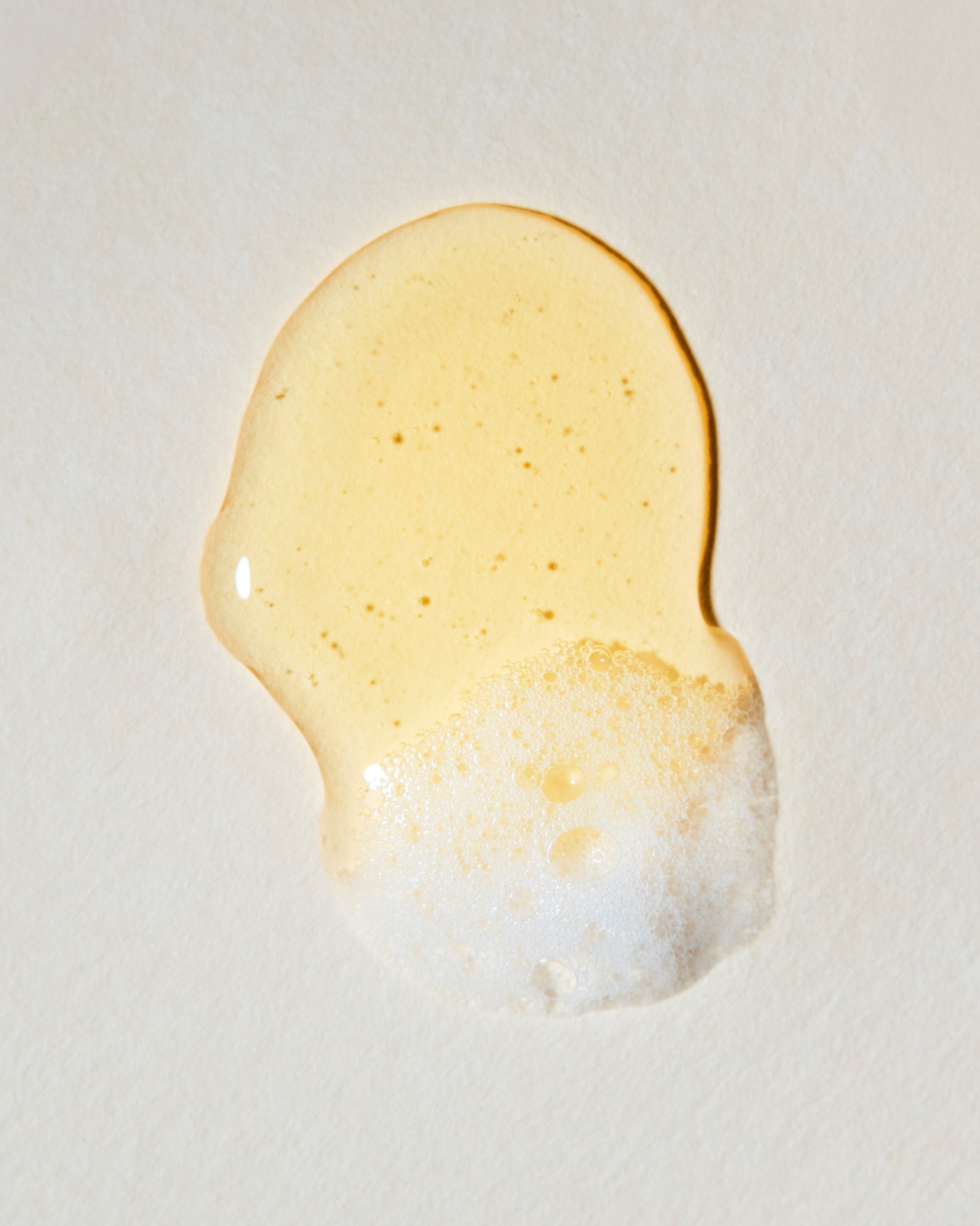 Close-up of a droplet of honey on a light background|variant:93-oz,18-oz