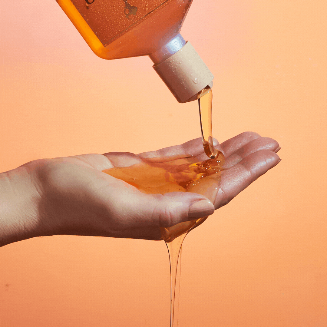 gif of a model dispensing rahua enchanted island shampoo in her hand, thin orange product|variant:93-oz